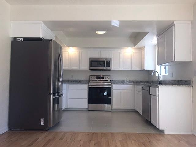 Fully renovated kitchen with new appliances, cabinets, granite counters, and tile floors. Clean, fresh, and crisp.