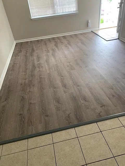 Luxury Vinyl tile in Living area, 
Tile in Dining and Kitchen area.