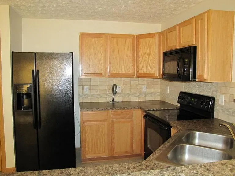 Kitchen with ceramic floor & black appliances