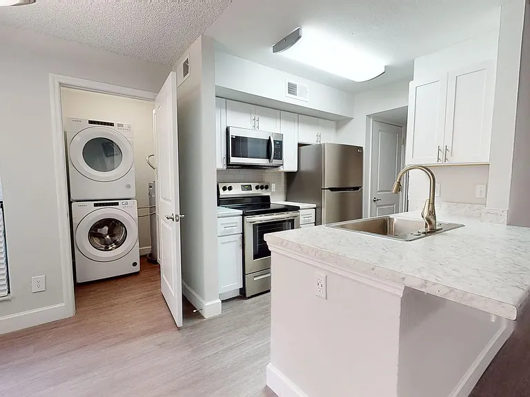 The Martinique floor plan offers a sleek kitchen with stainless steel appliances and an laundry area with a full-size washer and dryer, designed for your convenience.