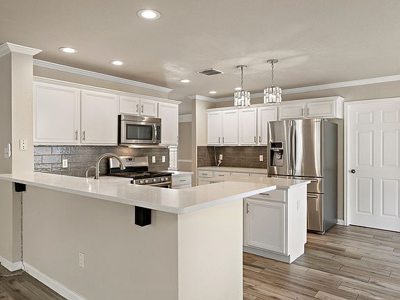 Fully remodeled chef's kitchen with quartz counter tops, modern backsplash, and stainless steel appliances