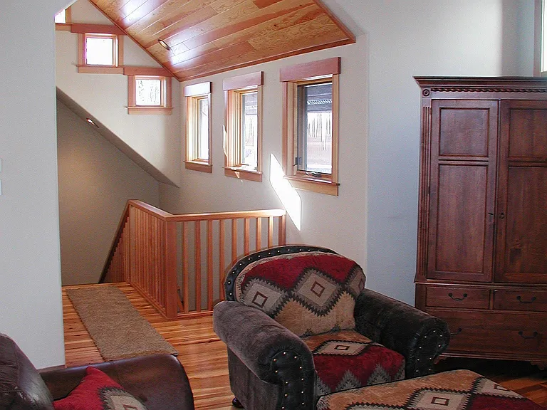 There is a deck off the great room with a dining table and barbecue. there is another set of windows and 2 couches to the right if this picture and then the sliding glass doors to the deck.