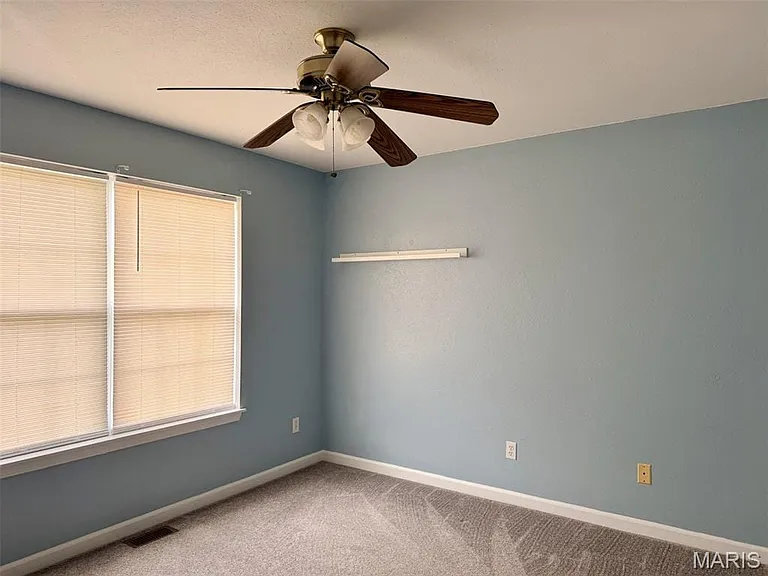 Ceiling fan with light fixture, window with blinds, and wall-to-wall carpeting