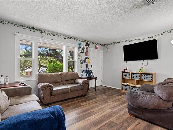 Wood-finish flooring throughout, bright window with white trim, light gray wall paint, and recessed ceiling
