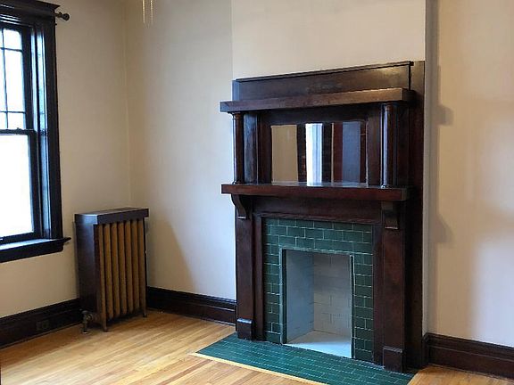 Original fireplace with charming mirrored mantle with tile surround.