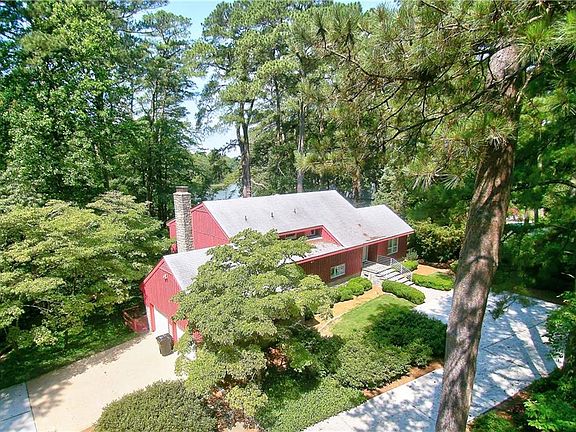 The cove is "peeking out" from behind the house. Custom stainless steel chimney cap and grill  prevents anything from blowing down the chimney. The entire driveway is concrete. The trees to the right of the garage door are dogwoods. the lower trees to the left of the house are  a dogwood forest.