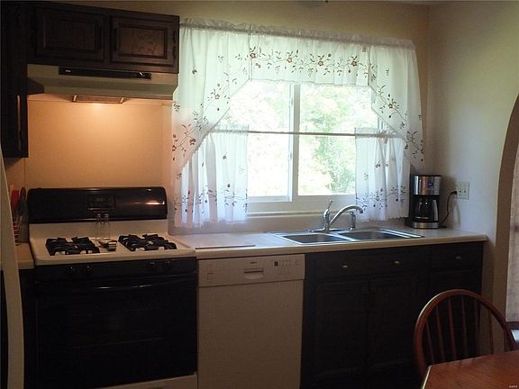 Kitchen has gas range and oven and large picture window looks out over back yard and common ground.