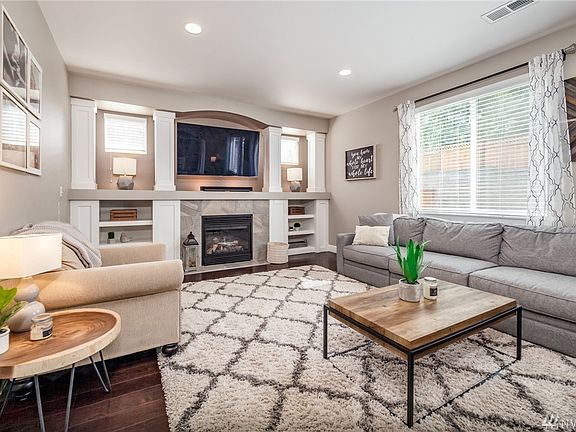 Living room has built-in shelves, gas fireplace