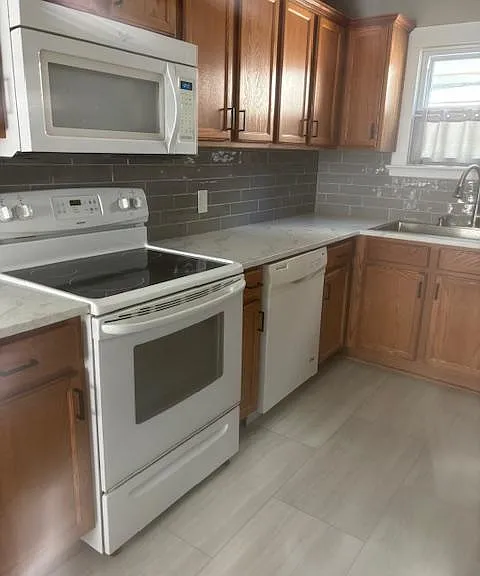 Updated kitchen! New sink, countertops, backsplash, faucet, lighting, cabinet hardware.