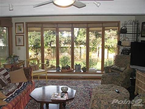 Family room with wood parquet floors, exposed beams, gas log fireplace and a 12 foot bow window overlooking the yard.