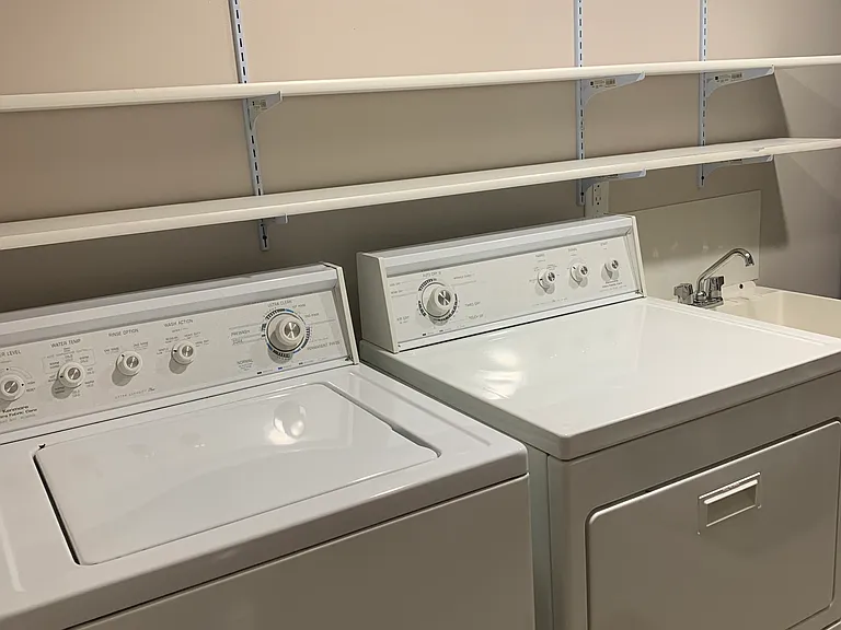 Laundry room with wash machine, dryer, utility sink and additional shelving