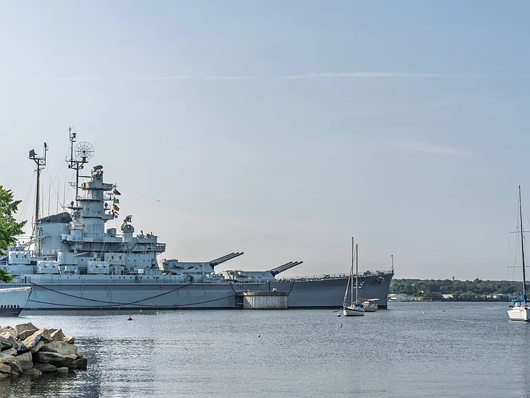 Battleship Cove tour historic naval ships and soak in river views about 12 minutes away.