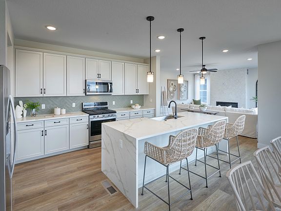 The Quincy kitchen shown with stunning white cabinets and a quartz island.