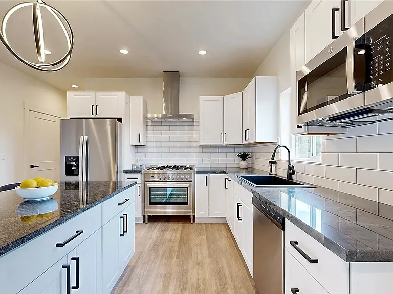 A beautifully designed chef's inspired kitchen featuring granite countertops, bar seating, and stunning mountain views, perfectly blending functionality, style, and the beauty of Montana living.