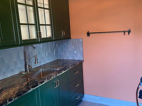 Deep green wood cabinets with ceramic countertops