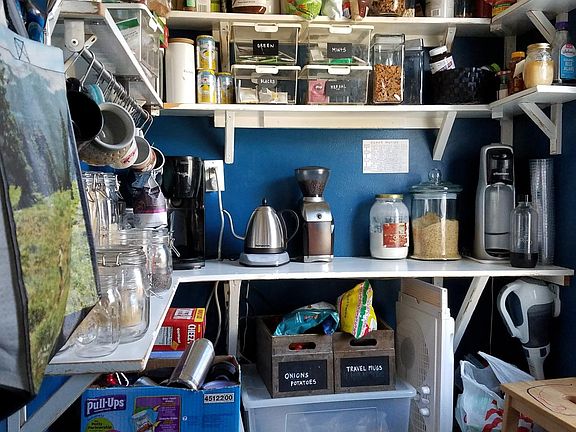 Walk-in pantry off the kitchen, lined with shelves. You can_