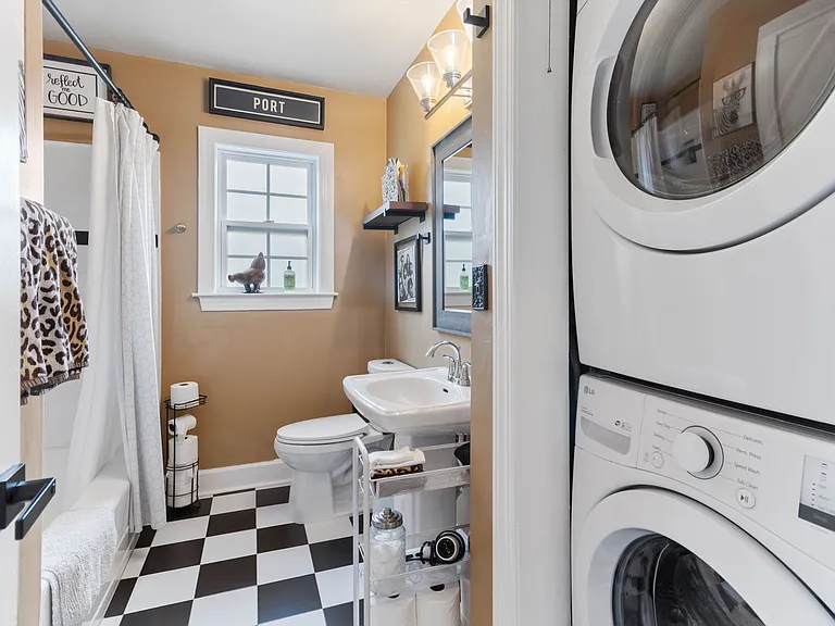 Modern bathroom at Hunsucker's Place, featuring updated fixtures, a full shower, and ample natural light. Conveniently located near Downtown Greensboro and Cone Health Hospital, this space combines functionality and comfort in a central, historic home.