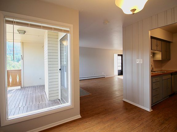 Taken in dining room looking back towards front door. Balcony thru window and kitchen to the right.
