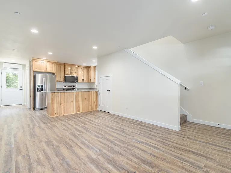 Living and Dining area with View of Kitchen and Stairs to Upper Level