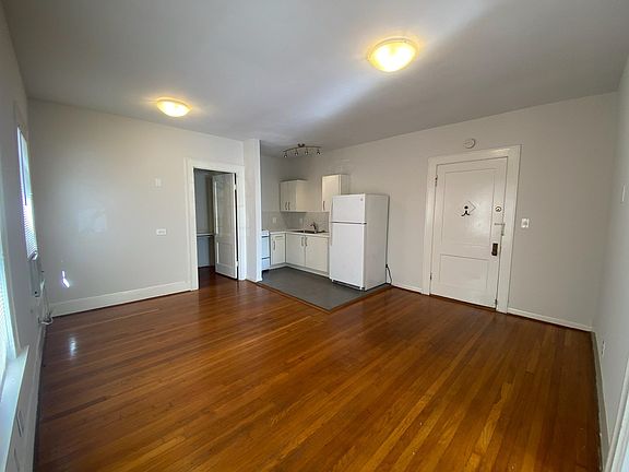 Alternate view of living room looking towards the kitchen, dining space and bathroom.