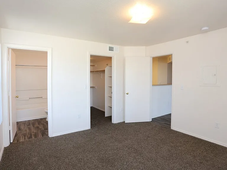 Bedroom with plush carpeting and a private bathroom