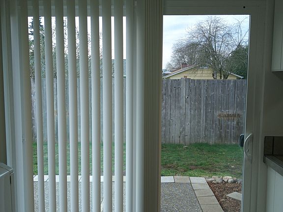 Kitchen nook dining facing new sliding glass door to backyard aggregate patio and fully-fenced backyard