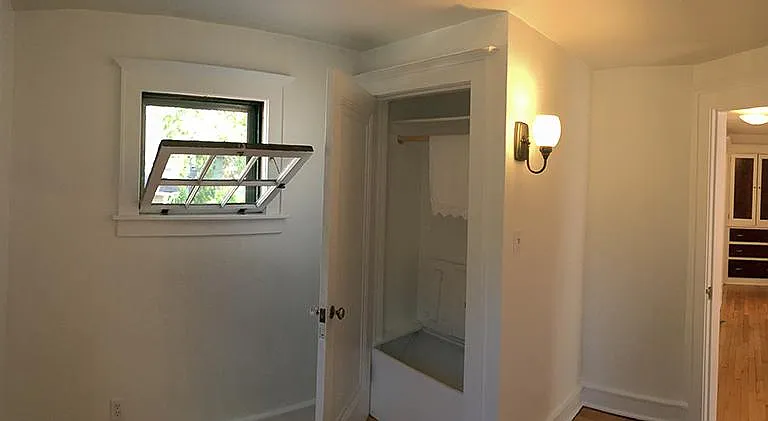 Small bonus room/ home office with small closet, north /north east facing. Looking down the hall to original built in storage cupboard off upper full bath. One upper bath in home. Pls note, no main floor bath.