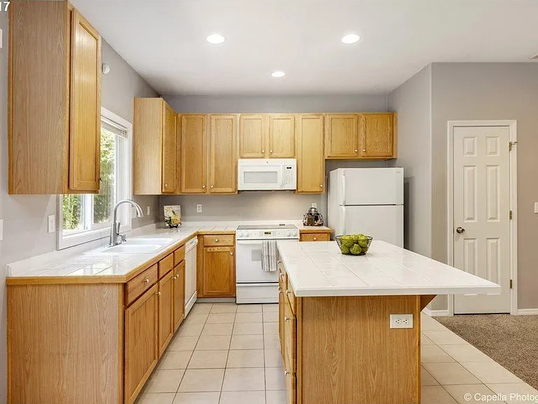 Kitchen with large counter top , appliances and dedicated pantry .