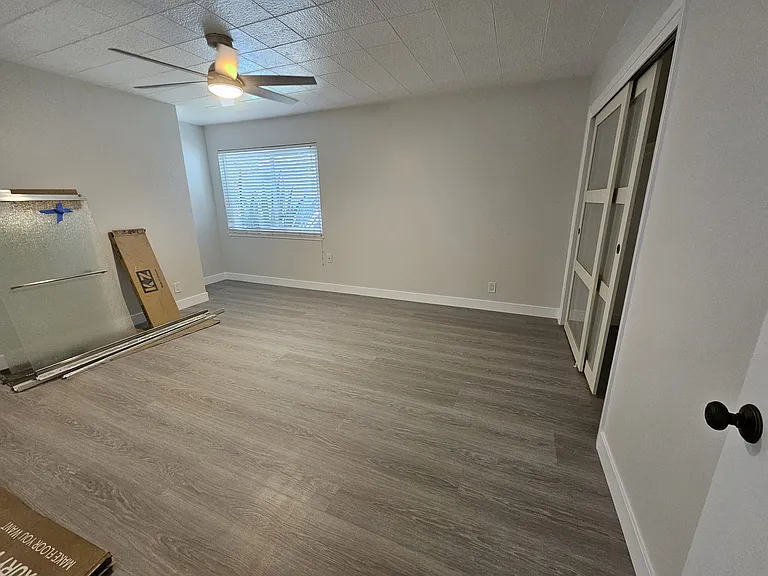 Large second bedroom with new ceiling fan and vinyl plank floors.
