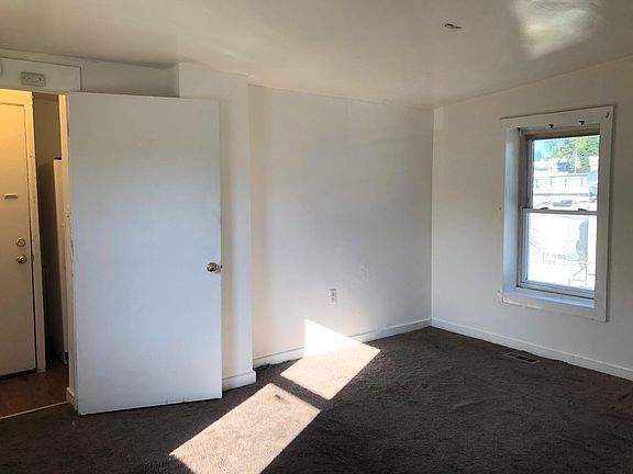 Living room, viewing from front bedroom toward front door and kitchen. Has also been used as a bedroom so it has a door to kitchen.