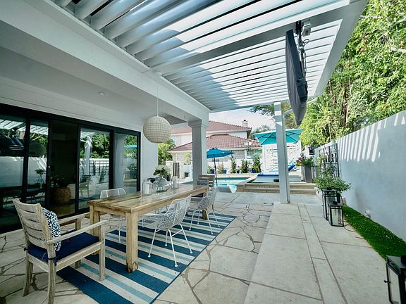 Outdoor pergola with blades that close to make a fully covered outdoor room
