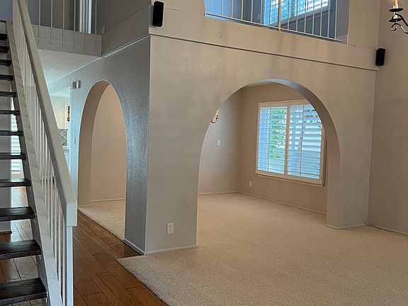 Oak hardwood floor at entry down hallway to family room and kitchen, luxurious carpeting in formal living and dining rooms