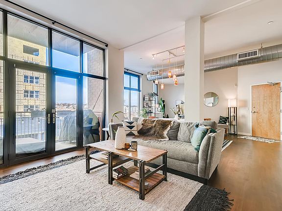 Living room with balcony doors and views to the northwest. Door on right is the entrance from interior hallway.
