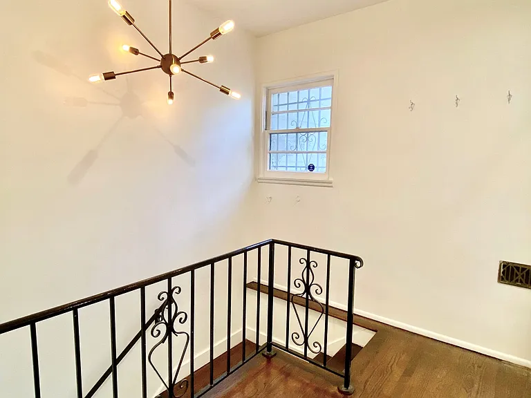 Entry stairwell with starburst gold light fixture and Edison bulbs.
