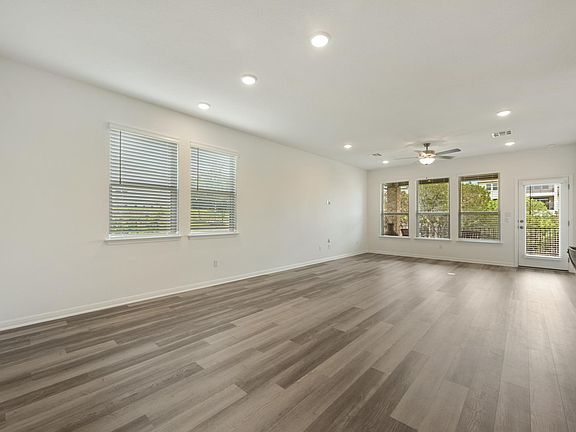 Living room is spacious and has views to the back yard that backs to a green space.