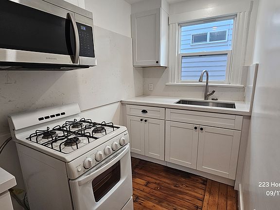 Kitchen with a sink, a brand new microwave, and stove