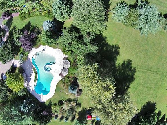 Similar view shows a bit more of the splendid rear yard with a glimpse of the playset. Great for soccer, baseball, football, or the outdoor activity of your choosing. This can be your own personal resort.