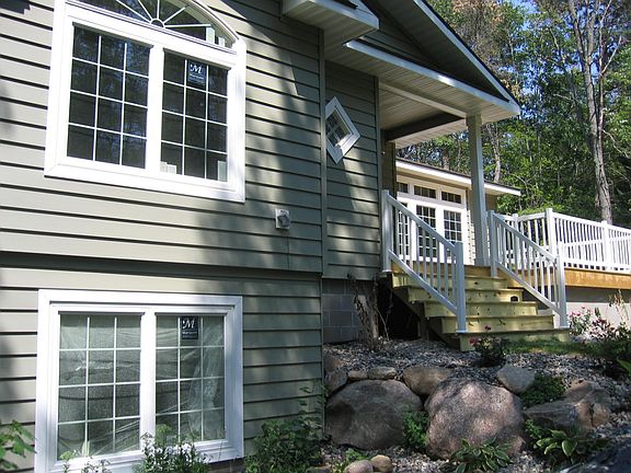 South side entrance and view of # 2 bedroom (upper) and # 4 bedroom (lower) windows. Living room window to the right over the deck.