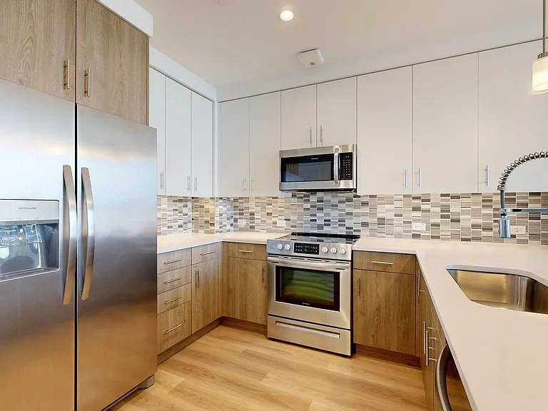 Apartment Kitchen with Quartz counter tops and Wood Style Flooring.