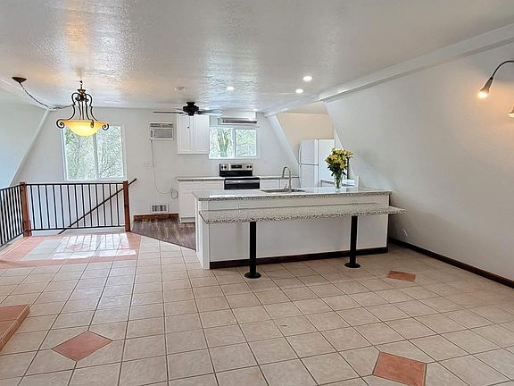 View from the great room with wood burning stove, seamlessly flowing into the kitchen, with a long granite table (for your computer, cookbooks, etc.)
