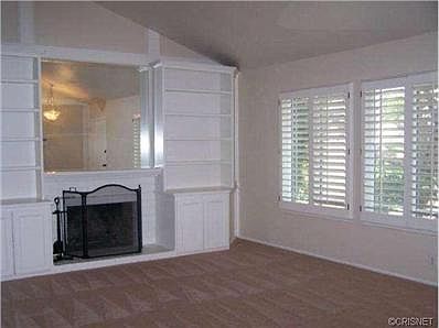 Spacious Living Room with mirrored Fireplace, and Custom Built-i