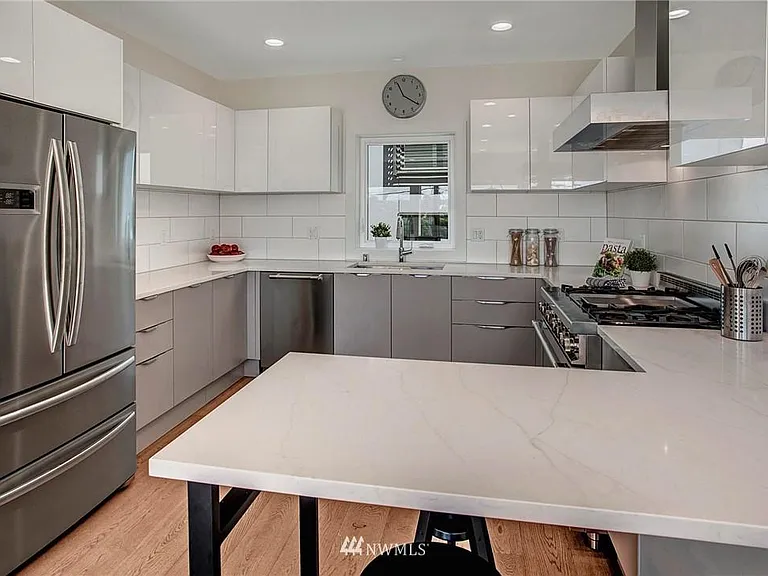 The sleek high-end kitchen features chef's grade stainless steel appliances, marble casual counters, plentiful cabinets and a wine fridge.