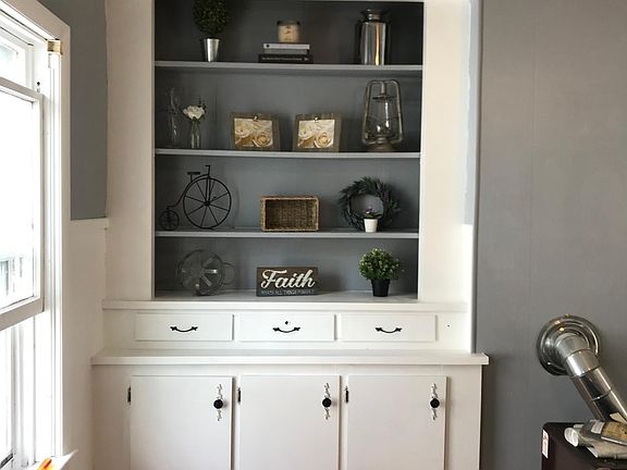 Beautiful vintage Built in with drawers cabinets and shelving in a cozy TV room with completely refinished hardwood floors.