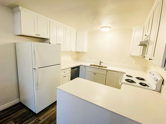 Kitchen with fridge, new dishwasher, new stove, quartz countertops.