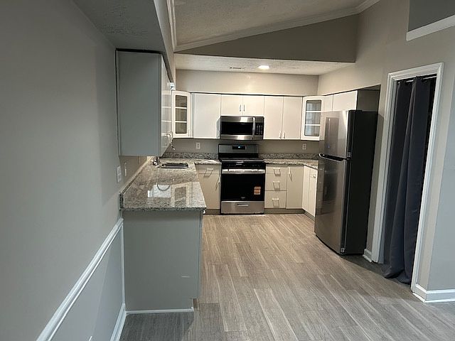 Kitchen with updated granite counters and new stove and refrigerator