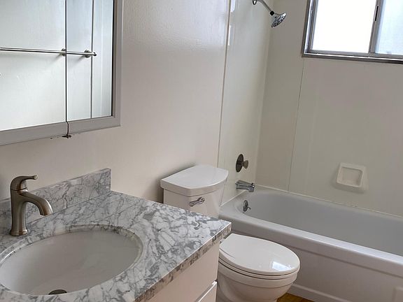 New bathroom wood floors, cabinets, quartz countertop, medicine cabinets, toilet and fixtures.
