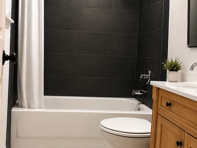 Updated primary ensuite bathroom with a tiled tub/shower surround, rainfall shower, modern vanity, contemporary finishes, and bright neutral flooring.