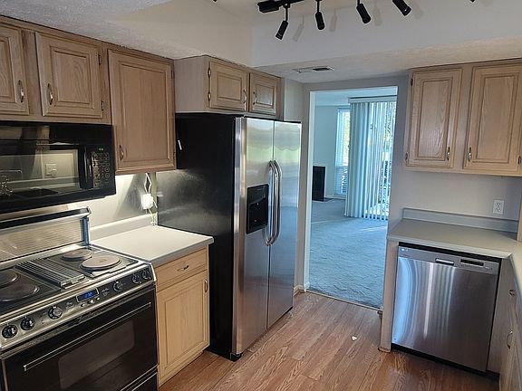 Chef's Kitchen with high-end luxury appliances and chef's style triple bowl stainless steel sink with waterfilter faucet, soap dispenser, rinser with stainless steel backsplash and professional undercabinet lighting