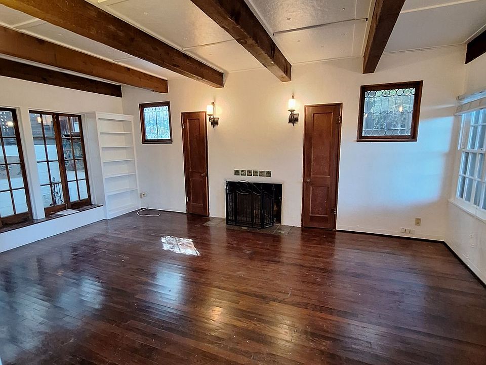 Charming and elegant living room, with a unique fireplace and two leaded glass windows, which are quite appealing. The beautiful Wood beams are from 1928, and quite elegant. There are two bookcases, and two larger windows, which brings in a lot of natural