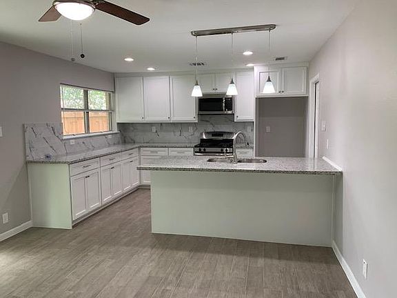 Completely remodeled kitchen with new shaker cabinets, granite countertops, and stainless appliances. Also includes a peninsula with counter height bar for additional seating.